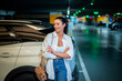 © gzorgz - Confident woman standing in car park next to her car