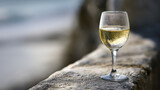 corretto. A clear glass of white wine on a stone ledge with condensation. bar promotions, beverage menus, designed for food & beverage menus and cafe branding, enhances appetite appeal.