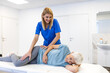 © Graphicroyalty - Smiling female therapist performing a hip stretch on a senior woman lying on a treatment table. Professional physical therapy session for elderly mobility in a bright modern medical clinic.
