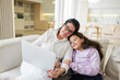 © muse studio - Mother and daughter enjoy time together while using a laptop at home in the afternoon