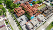 © rafaelnlins - Vista aérea de condomínio residencial com casas, ruas internas, piscina e áreas urbanas ao redor, destacando moradias, planejamento urbano e vida em bairro brasileiro.