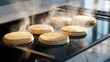 © Noman - Steaming hot pancakes cooking on a black griddle with golden brown tops and rising steam