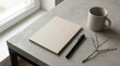 © mohdfaizal - Blank notebook and pen on a minimalist desk surface