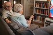 © Halfpoint - Lovely senior couple watching television in the evening.