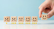 © SALMA1234 - Hand choosing happy face on wooden block with stars rating