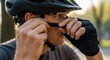 © Lena - Cyclist adjusting helmet strap outdoors preparing for activity