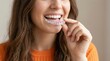 © Alamin - Smiling young woman putting clear plastic aligner on teeth for orthodontic treatment plan
