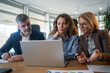 © Nenad - Creative startup team collaborating with AI software on laptop, modern workplac