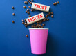 © Natallia - Trust Issues symbol. Wooden blocks with words Trust Issues. Beautiful deep blue background with coffee cup and coffee beans. Business and Trust Issues concept. Copy space.