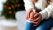 © svastix - A woman in a cozy sweater sits with a pained expression, gently holding her knee and capturing the struggles of discomfort, reflecting on human resilience and health.