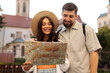 © Home-stock - Two tourists looking at map and smiling while exploring city, couple enjoying their travel adventure at summer time