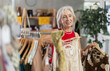 © JackF - Positive old lady looking for some summer wears during sell-out in retail outlet