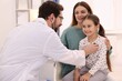 © New Africa - Little girl and her mother having appointment with pediatrician in hospital. Doctor checking child with stethoscope