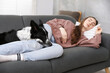 © New Africa - Young woman with her adorable dog sleeping on sofa at home