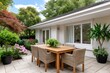 © kardaska - Modern outdoor patio dining furniture and lush garden