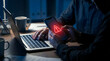 © CreativeAssetCo - Hacker holding smartphone with red warning triangle alert on dark screen,concept of mobile cyber security threat and malware virus,phishing scam fraud and data privacy breach risk.