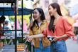 © Phimwilai - Asian women travelers enjoying street food at market