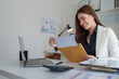 © crizzystudio - Young businesswoman reading important document in office mail