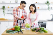 © sofiko14 - A couple prepares fresh ingredients for a cooking video in their bright kitchen
