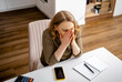 © 5ph - Distressed woman covering face with hands sitting at desk with notebook. Personal financial crisis, family budget despair, emotional breakdown, money loss anxiety, debt problems.