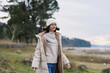 © SHOTPRIME STUDIO - Woman outdoors in a winter coat walking in a park, wearing a sweater and beanie, enjoying a chilly day by the lake with calm landscape and serene nature