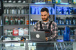 © Serhii - Auto parts store worker using laptop for inventory