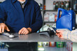 © Serhii - Customer paying for car parts and oil service