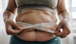 © luzaein - Tracking Progress Woman Measures Her Waistline to Monitor Weight Loss and Fitness Journey