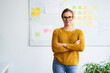 © baranq - Confident businesswoman with arms crossed standing in office