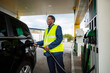 © Jelena - Gas station worker refueling car from fuel pump