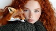 © Yuliia - Young redhead woman with freckles holding red fox close to face, curly hair, green sweater, wildlife portrait, nature connection, animal friendship concept.