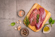 © petrrgoskov - Preparation for cooking raw duck breast with ingredients on dark background, top view. Space for text. High quality photo