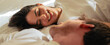 © Daniel - Beautiful happy loving young smiling couple relaxing in bed, looking at each other. Cozy home atmosphere, tenderness, closeness. Embracing, kissing. Lazy weekend, slow living concept