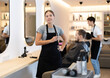 © JackF - Young female hairdresser stylist posing with scissors in beauty salon
