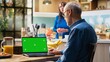 © DC Studio - Chroma key laptop with retired man checking display at the table in rustic kitchen, relaxed senior people spending their cozy lifestyle at home. Serving coffee and pastry. Camera B.