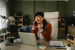 © Miljan Živković - Woman working from home talking on phone during video call