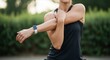 © Lena - Woman doing arm stretch exercise with fitness tracker at outdoor park
