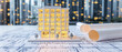© itlada - Modern architectural model on blueprints with rolled plans and city background, representing real estate development, urban planning, engineering, and future construction design concepts for business