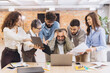 © anatoliycherkas - Overwhelmed senior employee experiencing burnout at work with young colleagues demanding attention and tasks, office pressure