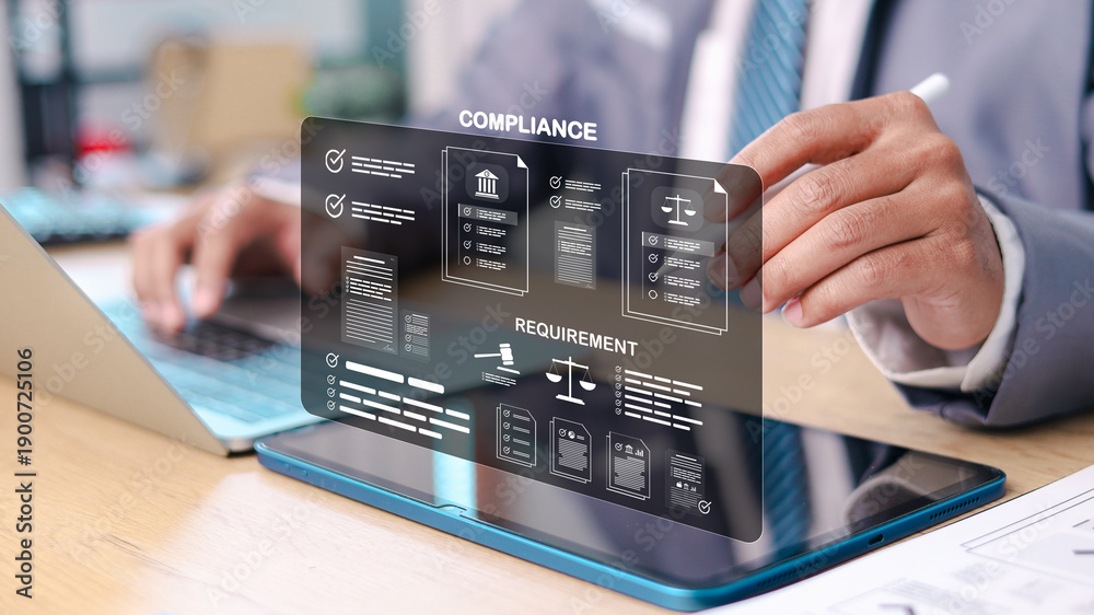 Businessman reviewing digital compliance dashboard with legal documents ...