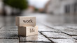 © Nattapol - Work life balance career lifestyle concept text wooden block street stone outdoor wet focus message metaphor choice decision stability harmony