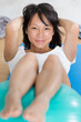 © auremar - asian woman using a pilates balll