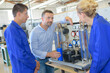 © auremar - engineer in factory with apprentices checking components