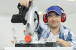 © auremar - skilled woodworker wearing safety gear using a mitre saw