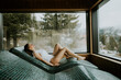 © BGStock72 - Relaxing woman enjoys peaceful spa experience on warm stone bed with scenic mountain view