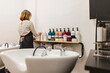 © PintoArt - Hairdresser organizing hair products at salon washing station