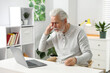 © New Africa - Unhappy senior man feeling fatigue at white table indoors