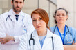 © StockMe - Serious medical team with a serious expression standing together outside hospital, doctors and nurse showing dedication to healthcare profession, with a serious expression
