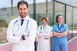 © StockMe - Healthcare team standing confidently outside hospital, doctor and nurses ready for patient care