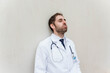 © StockMe - Exhausted doctor experiencing medical burnout, feeling stress and overwork, leaning against a wall during a hospital shift